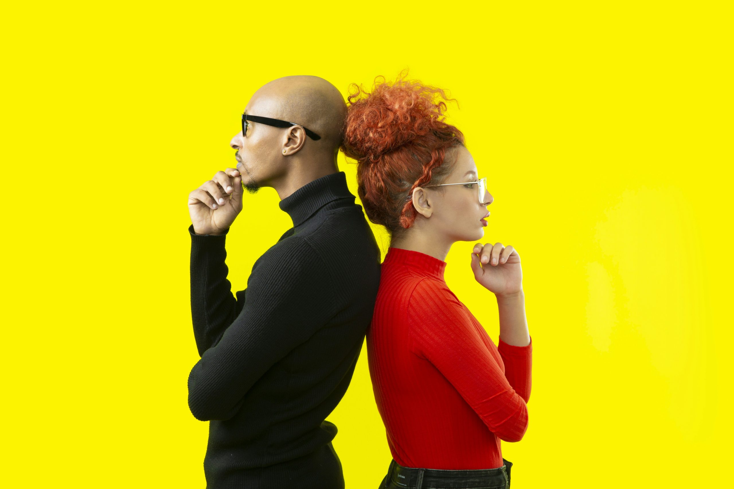 Brand Identity vs. Logo Two people standing back to back, both thinking, representing the decision between choosing a logo or investing in a complete brand identity for a business.